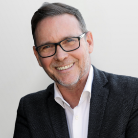 Markus Manheller - Vice President Supply Chain A smiling man with short, dark hair and glasses is wearing a dark blazer over a white shirt. He is leaning slightly to one side, with a neutral background, conveying a friendly and approachable demeanor.